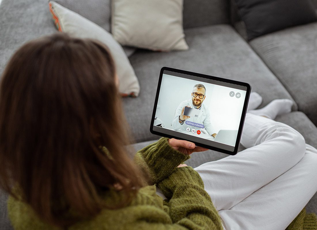 Employee Benefits - Woman Consulting a Doctor During a Telehealth Visit