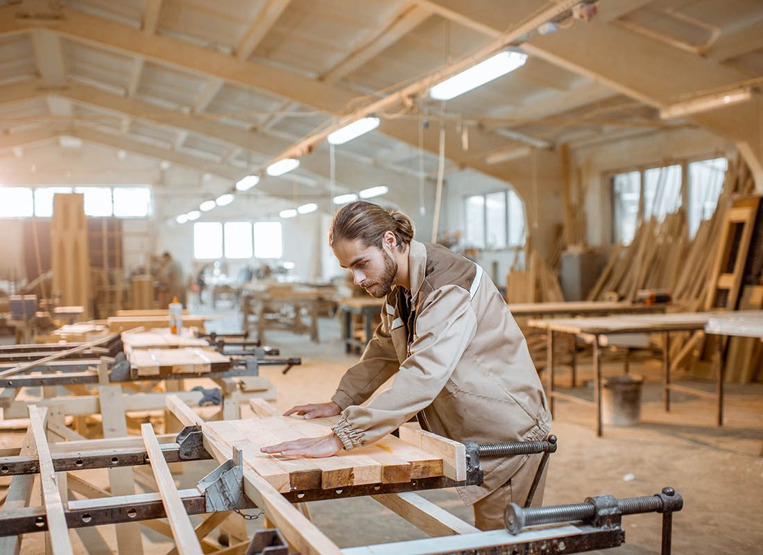 Carpenter Liability Insurance - Man Working In His Woodshop on a Large Wood Project