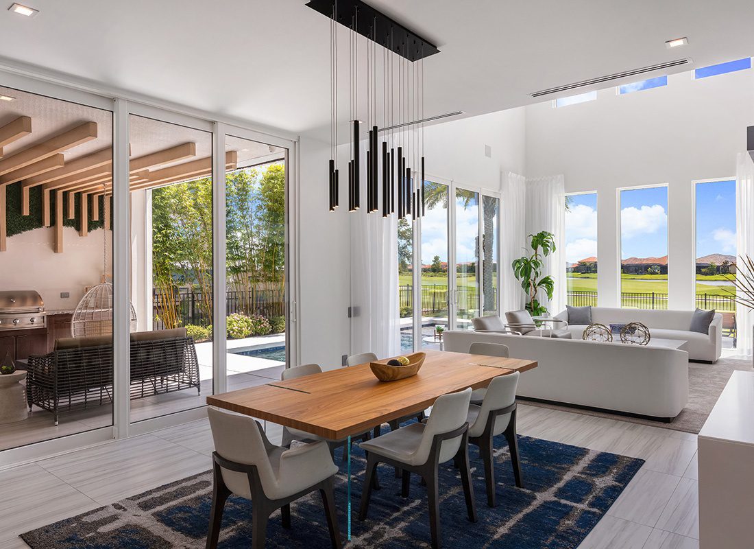 Personal Insurance - View of a Luxurious Modern Dining Room and Living Area with Large Glass Doors and Tall Ceilings with a Pool and Patio Area Visible Outside